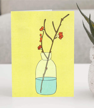 Greeting card featuring a minimalist illustration of a glass jar with water, holding delicate branches with orange blossoms on a yellow background.   