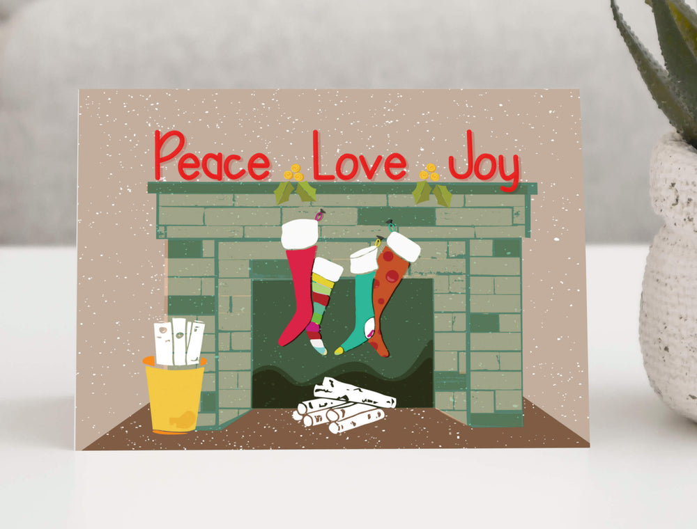 Festive holiday greeting card featuring a charming winter scene with colorful mittens hanging from a clothesline between two trees.
