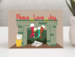 Festive holiday greeting card featuring a charming winter scene with colorful mittens hanging from a clothesline between two trees.